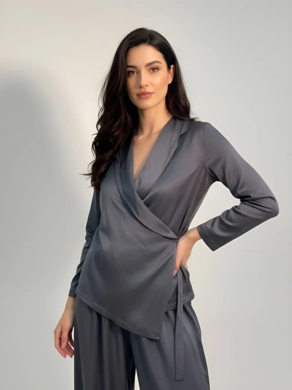 Elegant wrap-style top with long sleeves in a lightweight, satin-textured fabric. It gently follows the body with a waist tie for an adjustable fit, creating a minimal and refined look ideal for Beach Bar & Hostess staff. Can be paired with the matching trousers for a complete outfit.